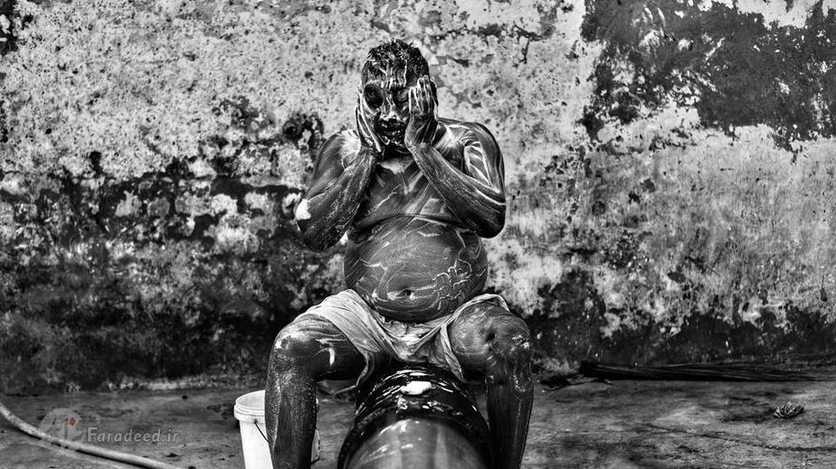 یکی کارگر در حال شستشوی خود پس از کار؛ کارگران می گویند بوی بد حتی با شستشو هم نمی رود و همیشه همراه آنها است.