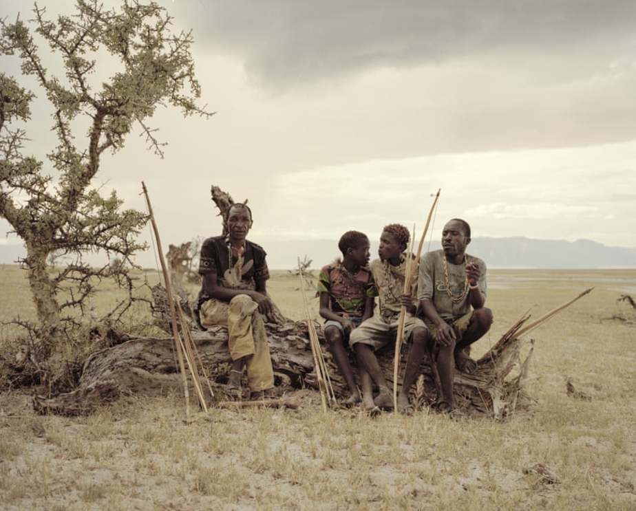 اهالی قبیله در حال استراحت روی تنه یک درخت خشک شده