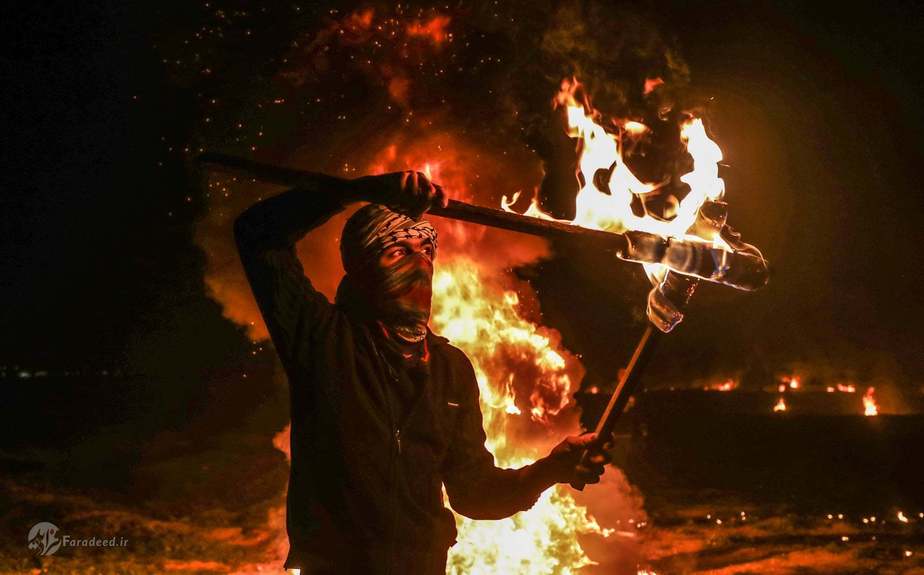 یک فلسطینی در حال درست کردن مشعل در «تظاهرات بزرگ بازگشت» در غزه.