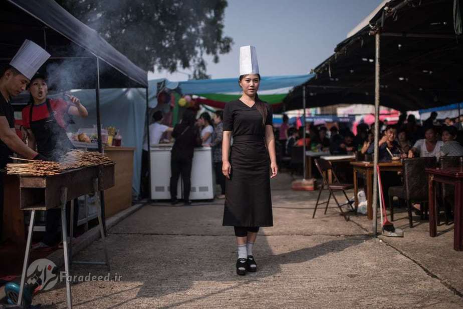 پیونگ یانگ، کره شمالی| آشپزی که در کنار غرفه اش در یک نمایشگاه تجاری در پیونگ یانگ ایستاده است