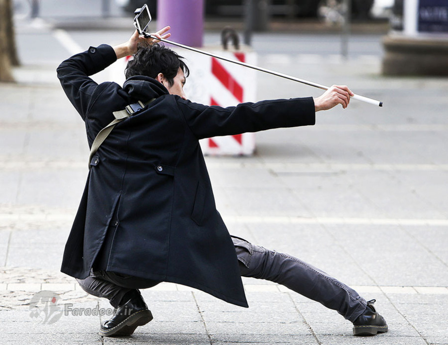 یک توریست چینی از اپرایی در فرانکفورت آلمان با گوشی خود عکس می‌گیرد