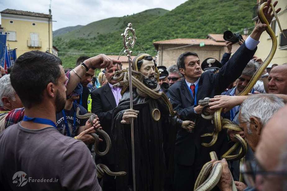 مردم در حال برداشتن مار از روی مجسمه هستند