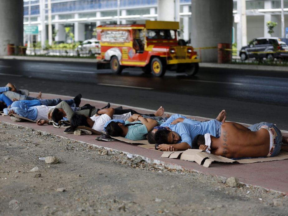 فیلیپین| کارگران ساختمانی فیلیپینی در حال استراحت در کنار خیابان پس از صرف ناهار