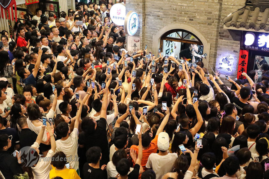 مردم در حال ضبط نمایش گروه برادران مدرن در خیابان اندونگ قدیم در ژاپن هستند