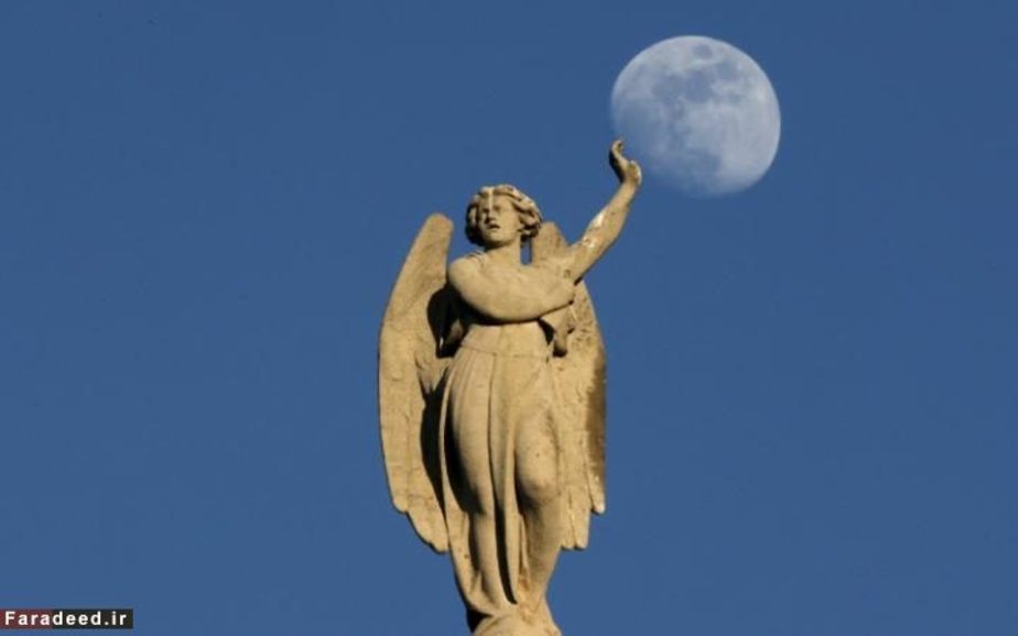 قرص ماه پشت مجسمه کلیسا، پاریس، فرانسه