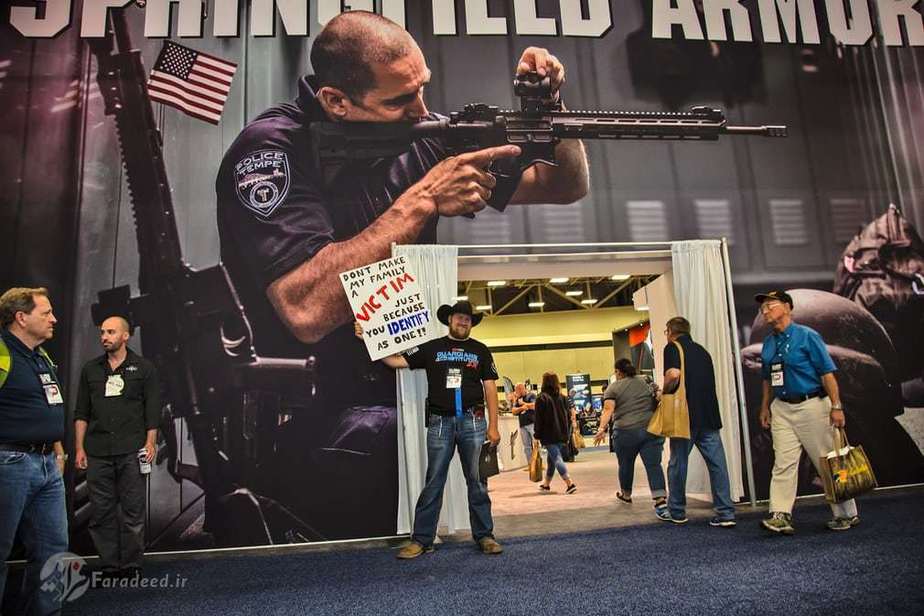 یعقوب ویتبارن، مربی اسلحه گرم، با یک علامت که برای اعتراض به فعالان ضد تفنگ حضور داشته است