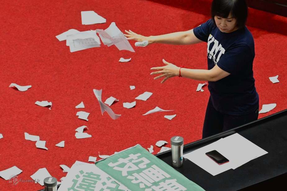  یکی از اعضای حزب KMT در حال پاره کردنِ برگه‌های رأی عکاس: Sam Yeh/AFP/Getty Images 